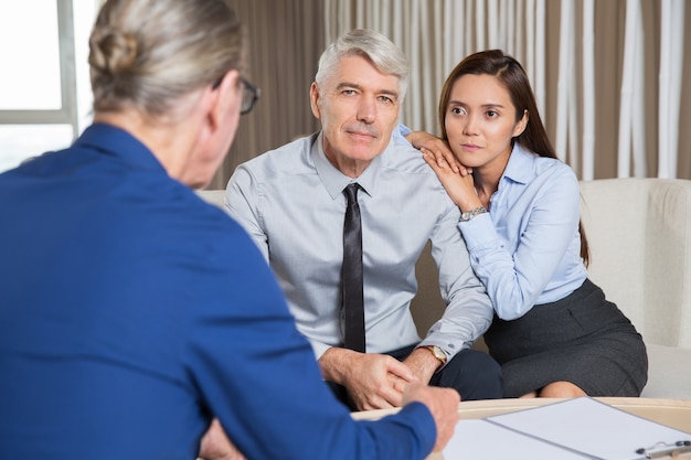 Senior ondernemers en jonge vrouw onderhandelen