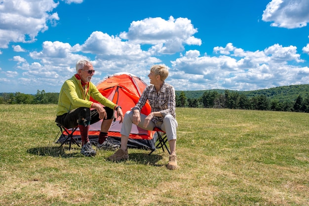 Senior paar met een rust in het veld met een tent