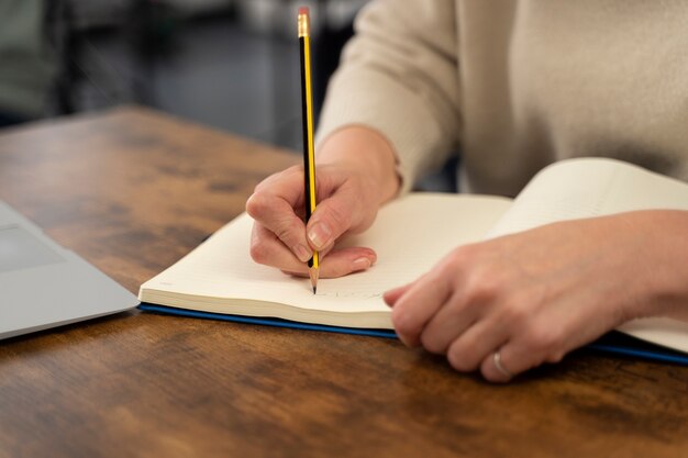 Senior persoon op school tijdens de les met notebook