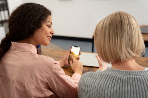 Senior persoon op school tijdens de les met smartphone