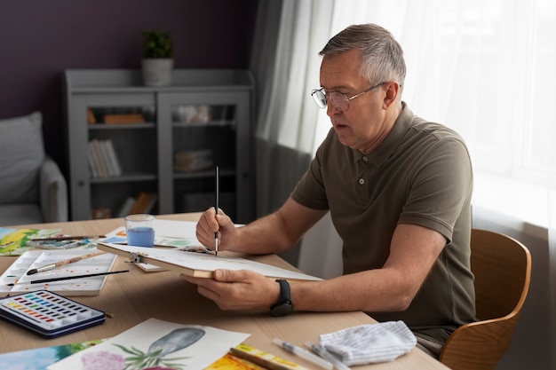 Senior schilder die waterverf gebruikt voor zijn kunst