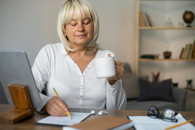 Senior vrouw die een online les volgt op haar tablet