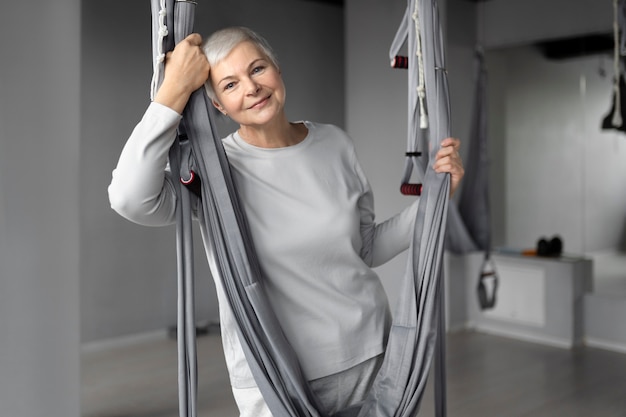 Senior vrouw doet een warming-up in de sportschool