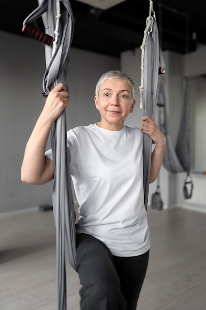 Senior vrouw doet een warming-up in de sportschool