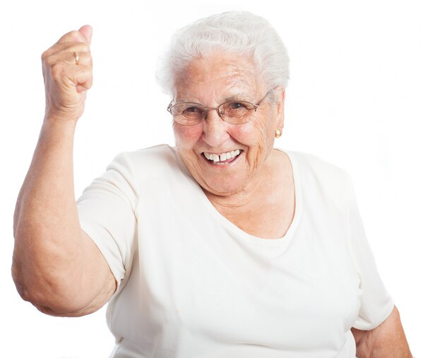 Senior vrouw glimlachend met een opgeheven vuist