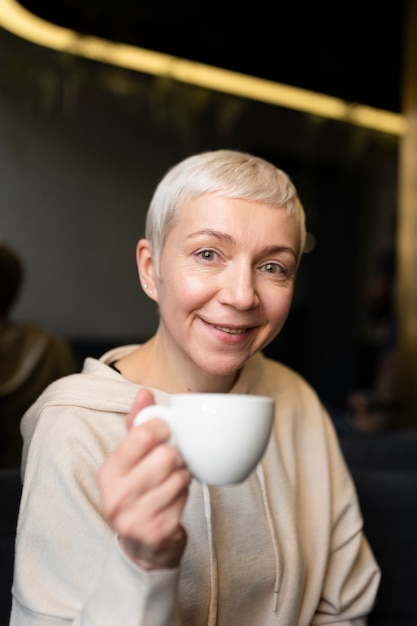 Gratis foto senior vrouw koffie drinken tijdens een bijeenkomst