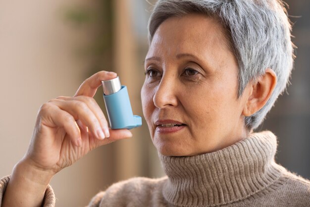 Senior vrouw met astma-inhalator