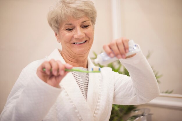 Senior vrouw met behulp van haar tandenborstel