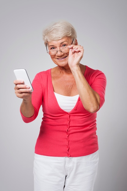 Senior vrouw met behulp van hedendaagse smartphone