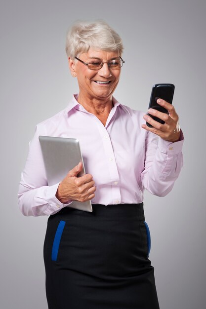 Senior vrouw met behulp van moderne technologie in haar bedrijf