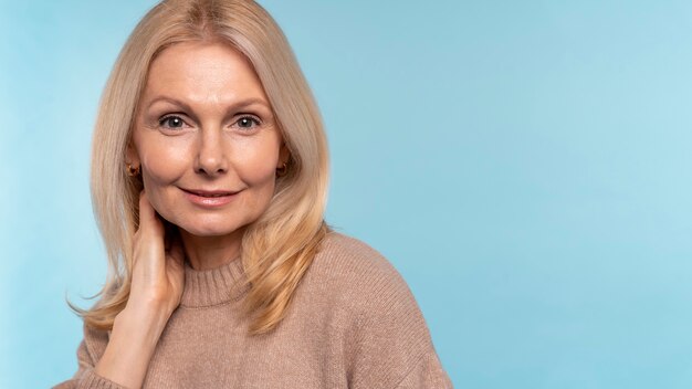 Senior vrouw poseren tegen een blauwe achtergrond