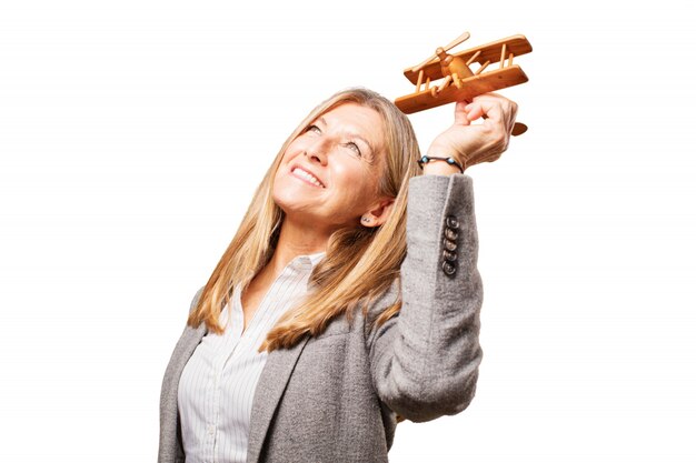 Senior vrouw spelen met een houten vliegtuig