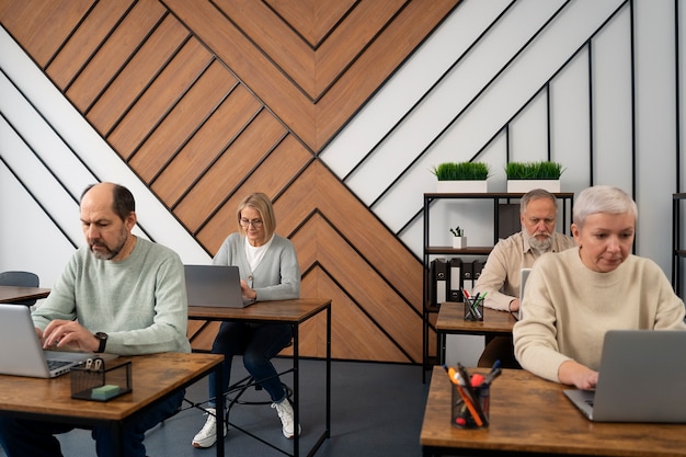 Senioren op school tijdens de les met laptopcomputer