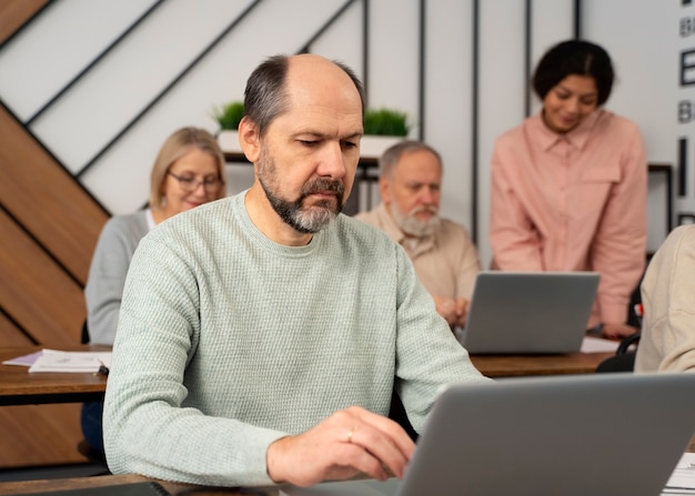 Senioren op school tijdens de les met laptopcomputer