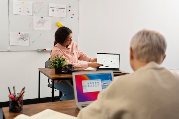 Gratis foto senioren op school tijdens de les met laptopcomputer