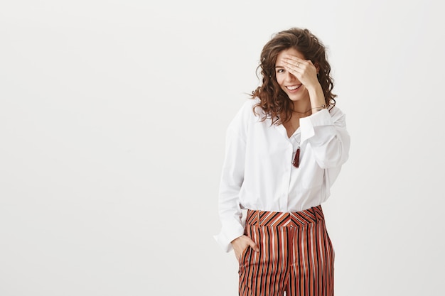 Sensuele aantrekkelijke vrouw bedekt haar ogen en dwaas lachend