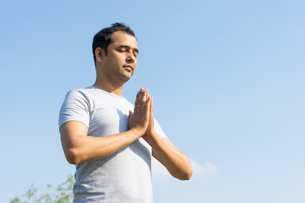 Serene Indiase man mediteren buitenshuis met zijn ogen gesloten en hand in hand