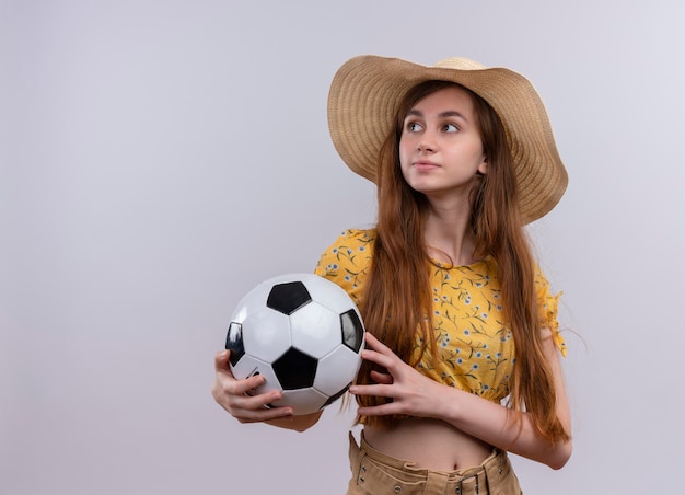 Serieus op zoek naar jong meisje dat het voetbal van de hoedholding draagt ?? die naar linkerkant op geïsoleerde witte ruimte met exemplaarruimte kijkt