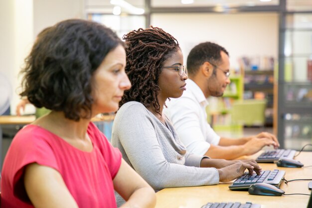 Serieuze mix racete studenten die in computerklas werkten