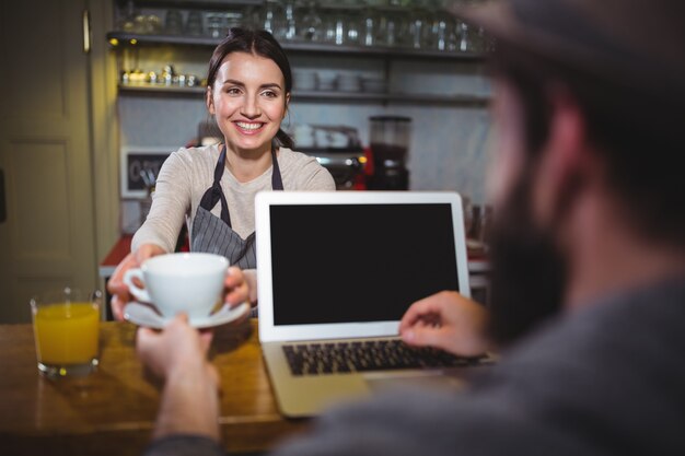 Serveerster serveren een kopje koffie aan de klant