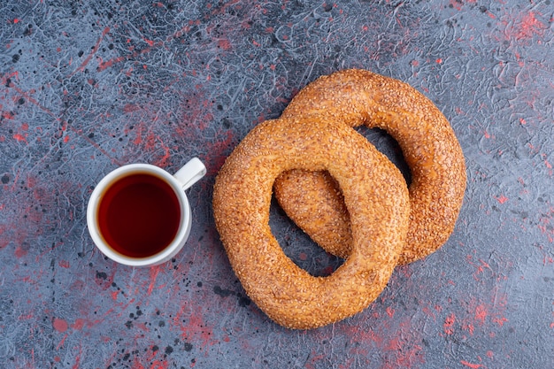 Gratis foto sesam bagels met een kopje thee.