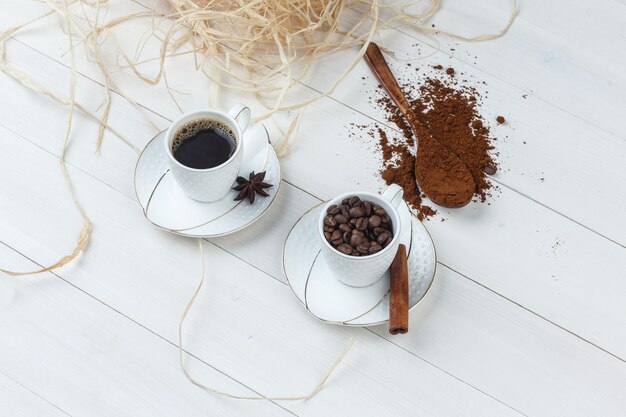 Set van gemalen koffie, kruiden, koffiebonen en koffie in een kopje op een houten achtergrond. hoge kijkhoek.