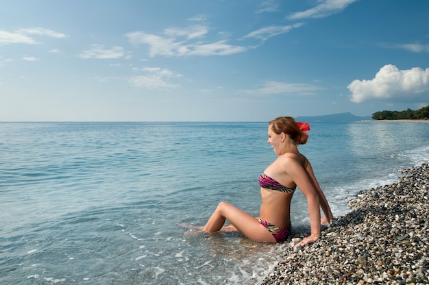 Sexy rode meisje dragen bikini op kiezelstrand