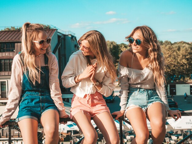 Sexy vrouwen die op leuning in de straat zitten Zij die en iets communiceren bespreken