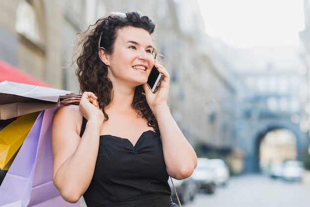 Shopaholic vrouw die op mobiele telefoon spreekt
