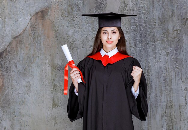 Shot van vrouwelijke student met afstuderen certificaat poseren. Hoge kwaliteit foto