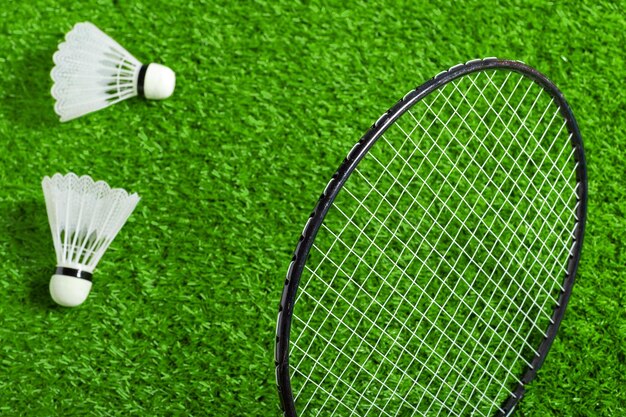 Shuttle en badmintonracket op groen gras