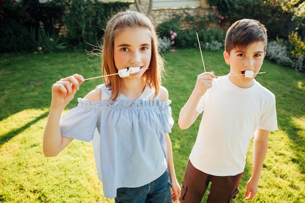 Gratis foto sibling marshmallow eten en camera kijken