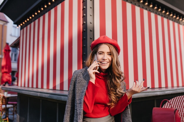 Sierlijke witte dame met smartphone in de hand hebben een goede tijd buiten