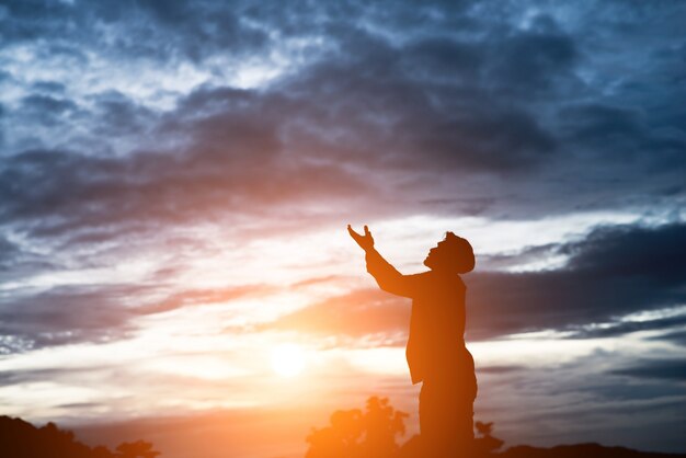 silhouet van de knappe Aziatische man bidden.