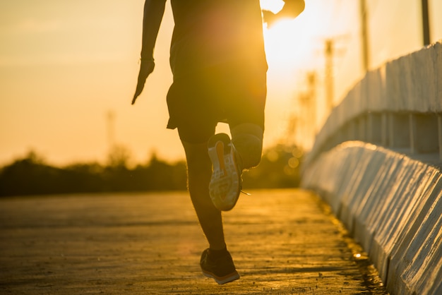 silhouet van een jonge fitness man loopt op zonsopgang