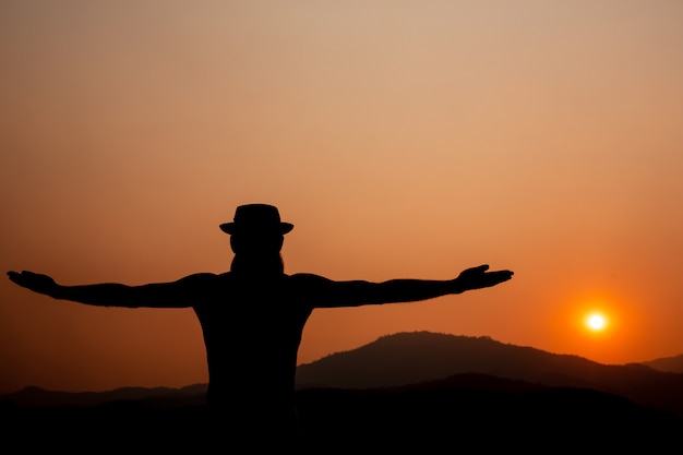 Silhouet van een man met uitgestrekte armen.