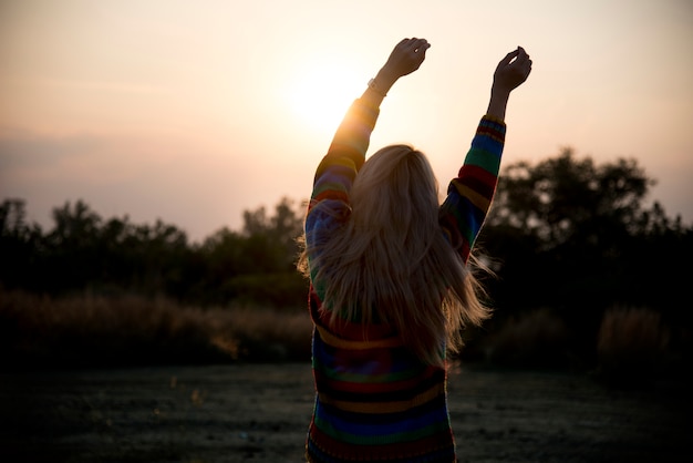 Gratis foto silhouet van een meisje die zich uitstrekt in de ochtend