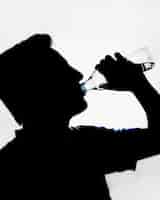 Gratis foto silhouet van man drinkwater