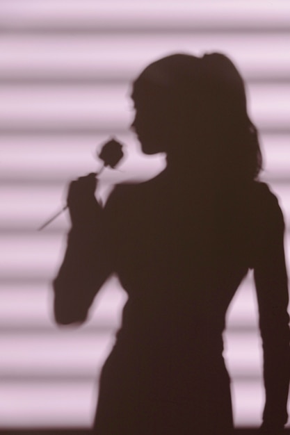 Gratis foto silhouet van vrouw thuis met vensterschaduwen