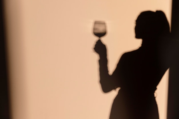 Silhouetten van vrouw die wijn drinkt