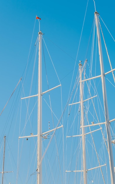 Silhouetten van wedstrijdjachten in de jachthaven tegen de achtergrond van een helderblauwe lucht verticaal frame idee voor een achtergrond of nieuws over zeilen