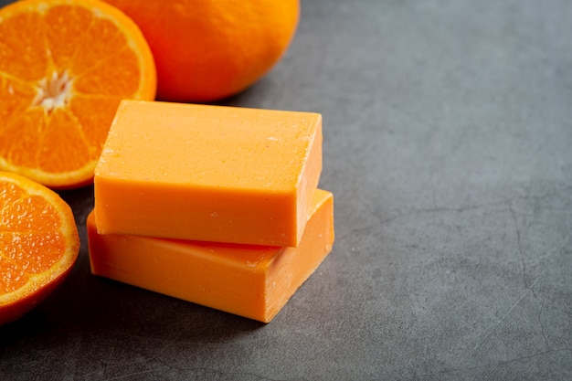 Sinaasappelzeep met verse sinaasappel op donkere achtergrond