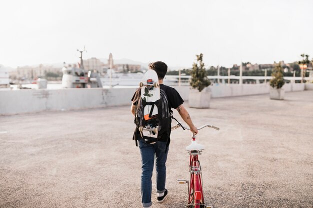 Gratis foto skateboarder die met fiets loopt