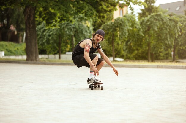 Skateboarder doet een truc in de straat van de stad op een bewolkte dag. Jonge man in sneakers en pet rijden en longboarden op het asfalt. Concept van vrijetijdsbesteding, sport, extreem, hobby en beweging.