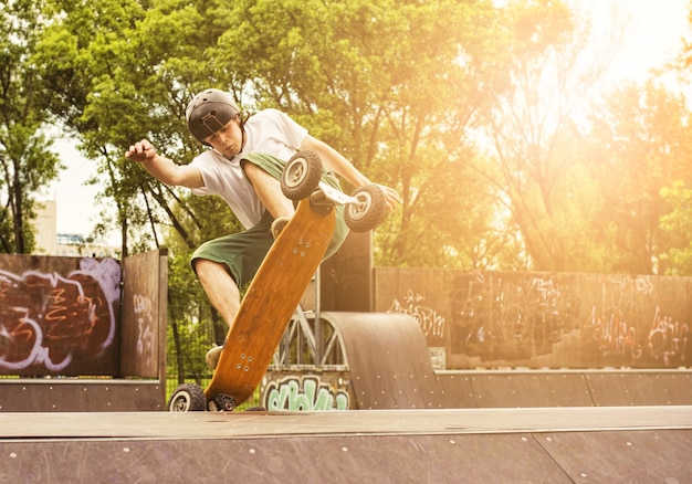 Gratis foto skateboarder doet een truc op skatepark onder de stralen van de zon