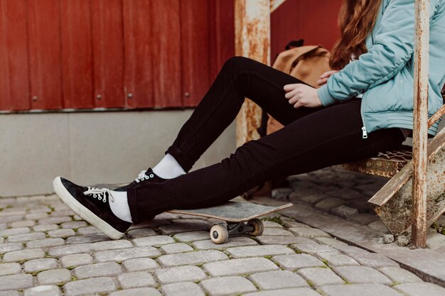 Skater meisje in de stedelijke zittend op trap zijaanzicht