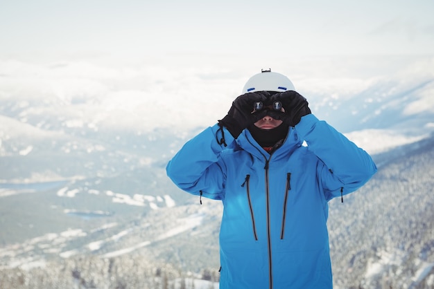 Skiër die door verrekijker kijkt