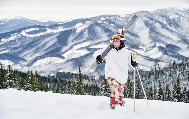 Skiër die ski-uitrusting draagt en tijd doorbrengt op berghellingen in het winterseizoen