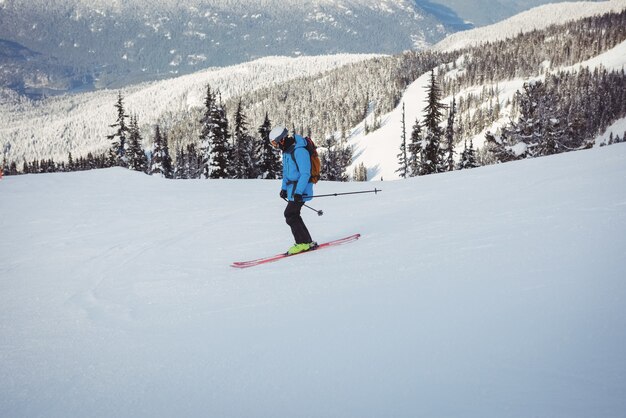 Skiër skiën op besneeuwde bergen