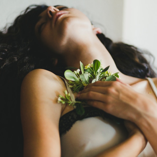 Slaapvrouw met bloemen dichtbij borst